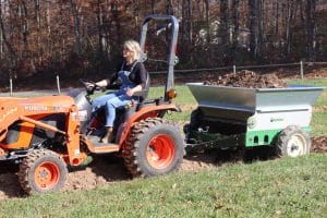 lady driving tractor bulling 248PT topdresser in her garden