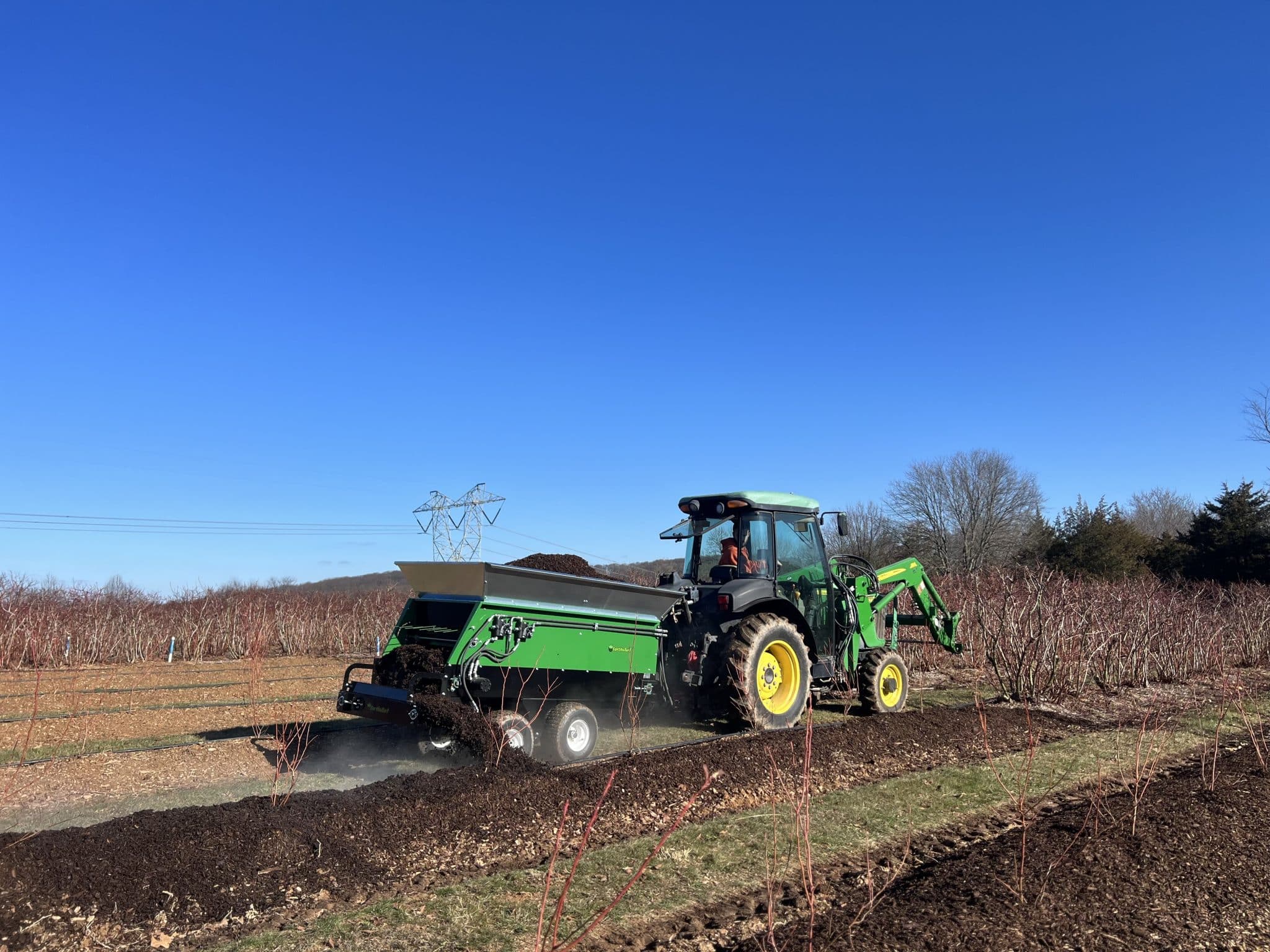 vineyard spreader spreading compost in CA