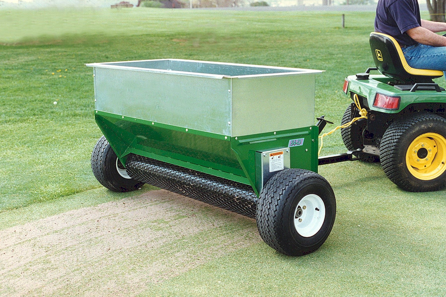 Large commercial pull behind drop spreader by Earth & Turf.