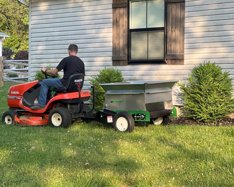 man mowing a topdressed yard with a push mower