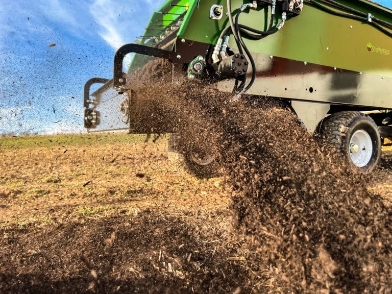 closeup of a mulch spreader in action