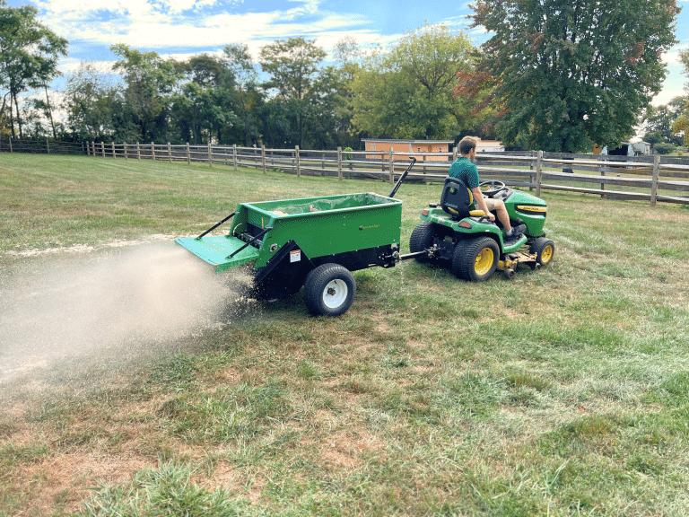 220 MS being pulled by a john deere tractor. multispreader used to spread sand on a pasture