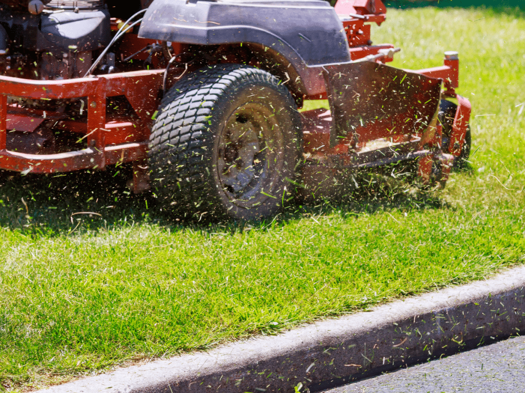 man mowing green grass because of compost spreading